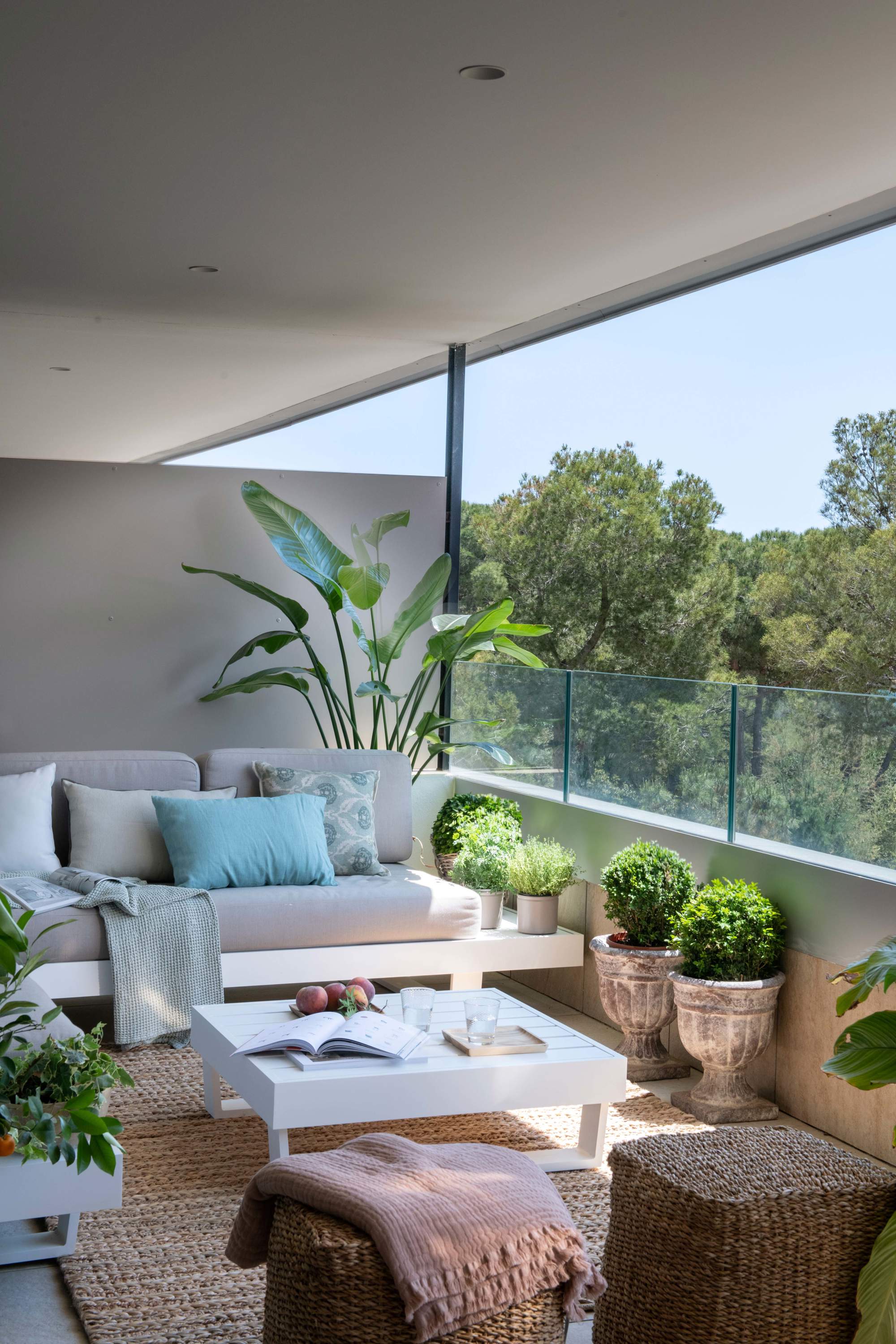 Terraza pequeña con sofá de obra y barandilla de cristal