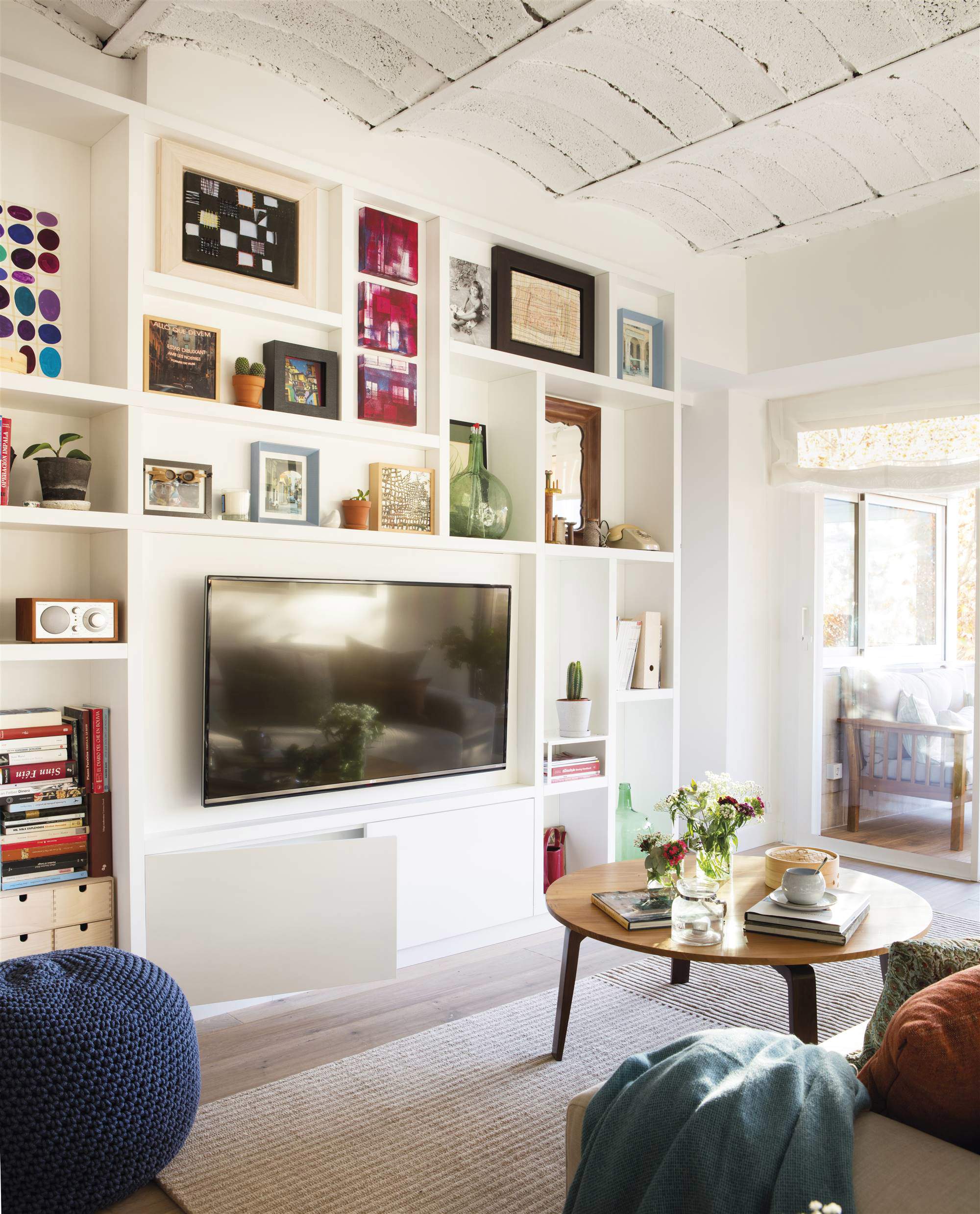 Salón con librería a medida en la pared que acoge el televisor.