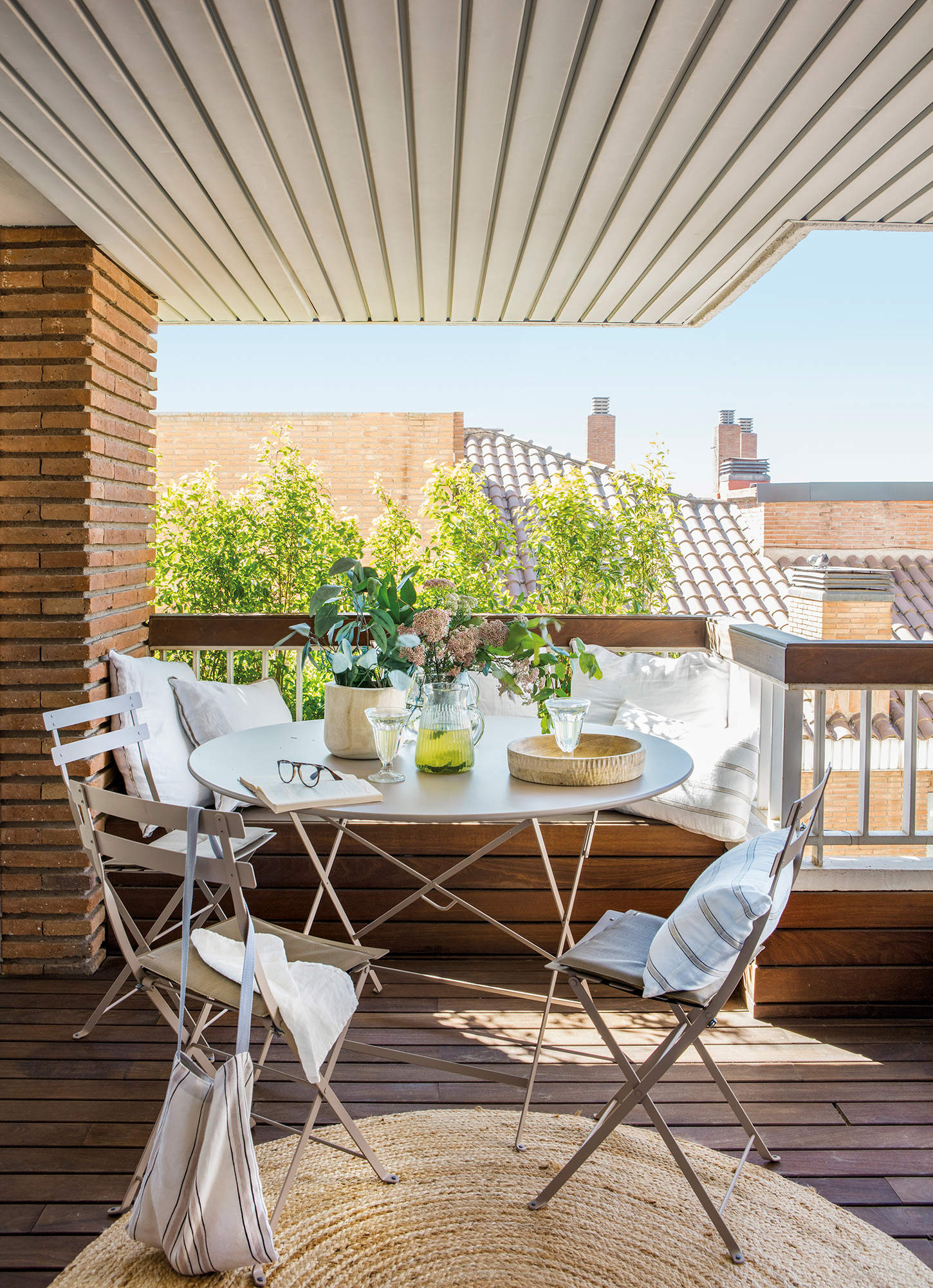 Una terraza con un banco de obra a modo de comedor