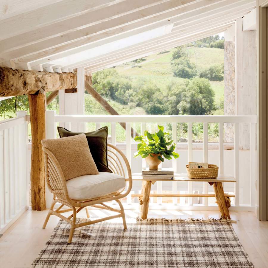 Terraza pequeña con sillón de fibra y mesa de madera