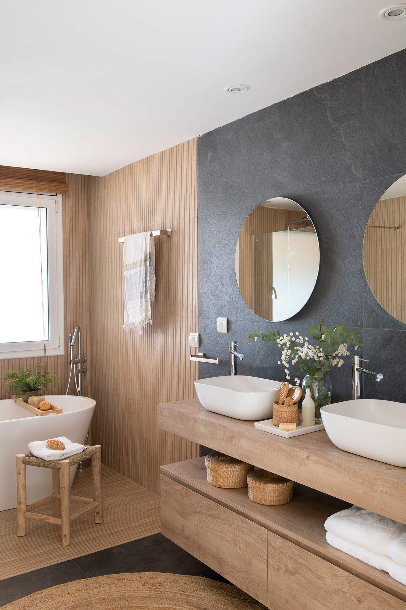 Baño con azulejos imitación madera y pizarra.