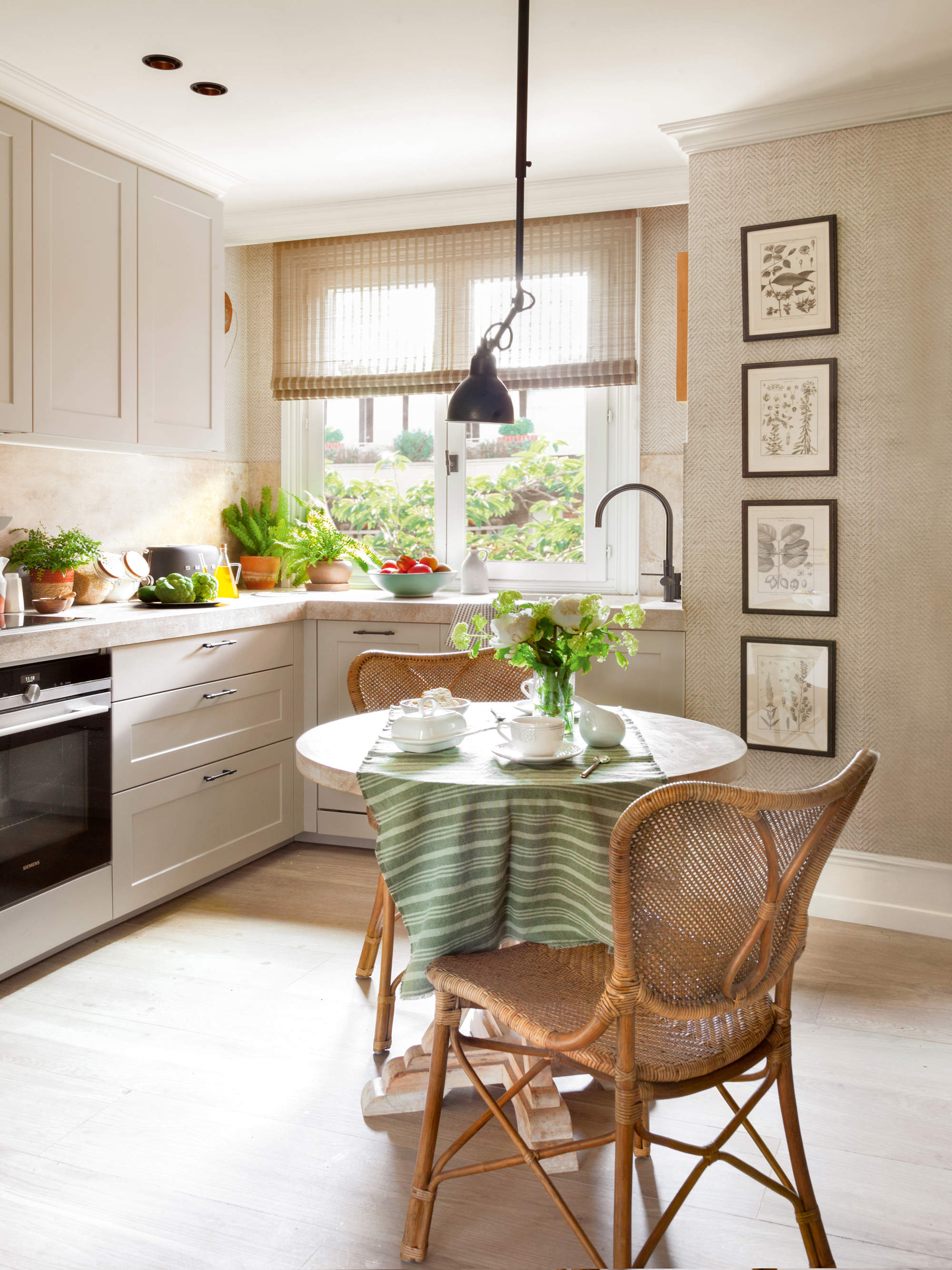 Cocina con comedor y pared decorada con cuadros.