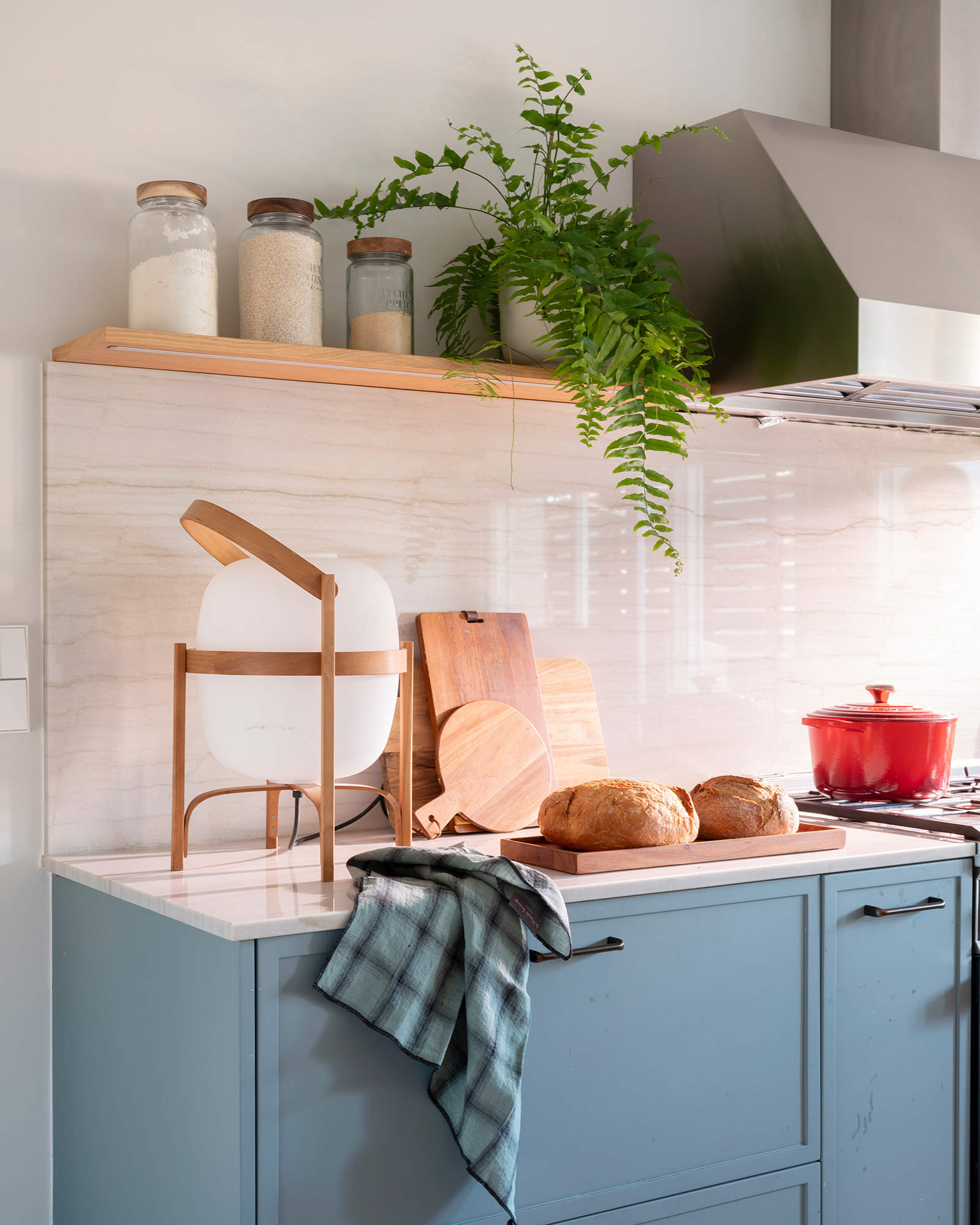 Cocina con muebles en color azul y lámpara de diseño 