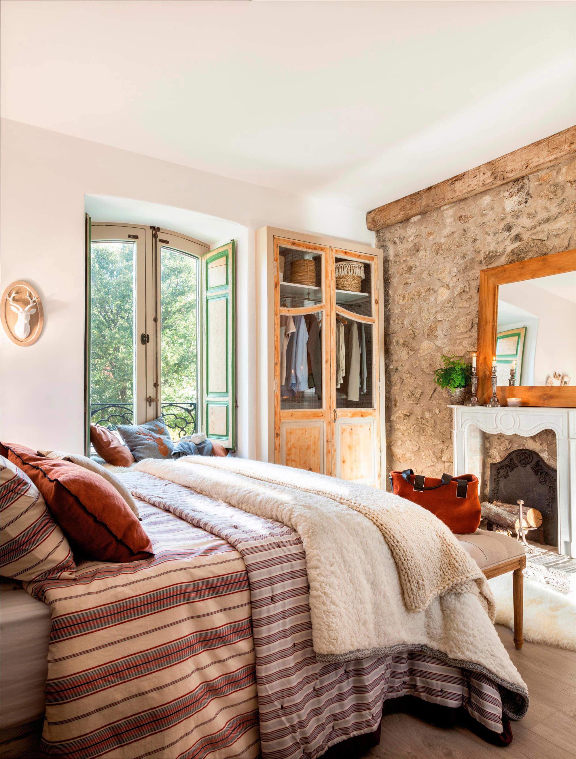 Dormitorio de invierno con chimenea y piedra en la pared