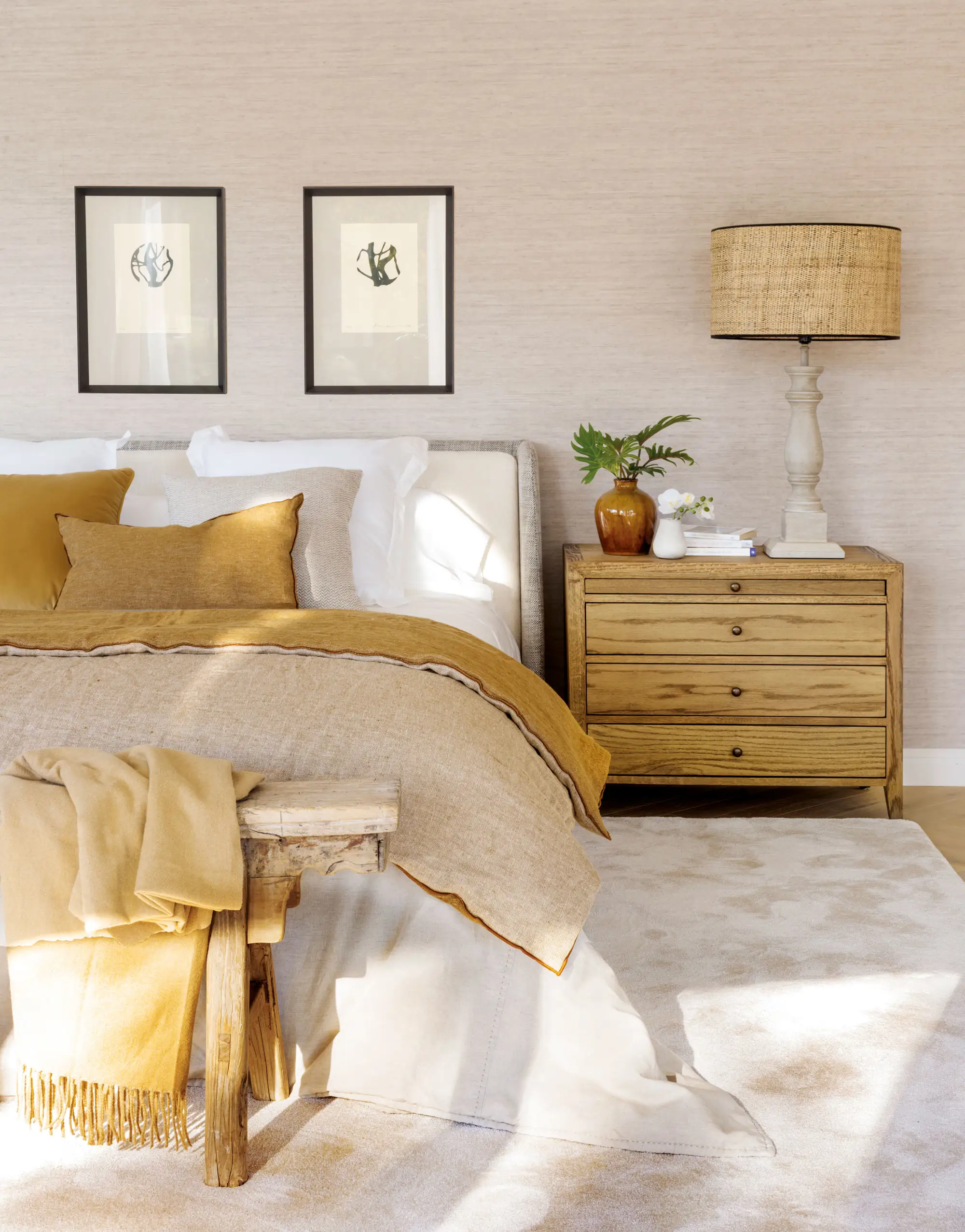 Dormitorio con pared texturizada, cabecero tapizado y cuadros.