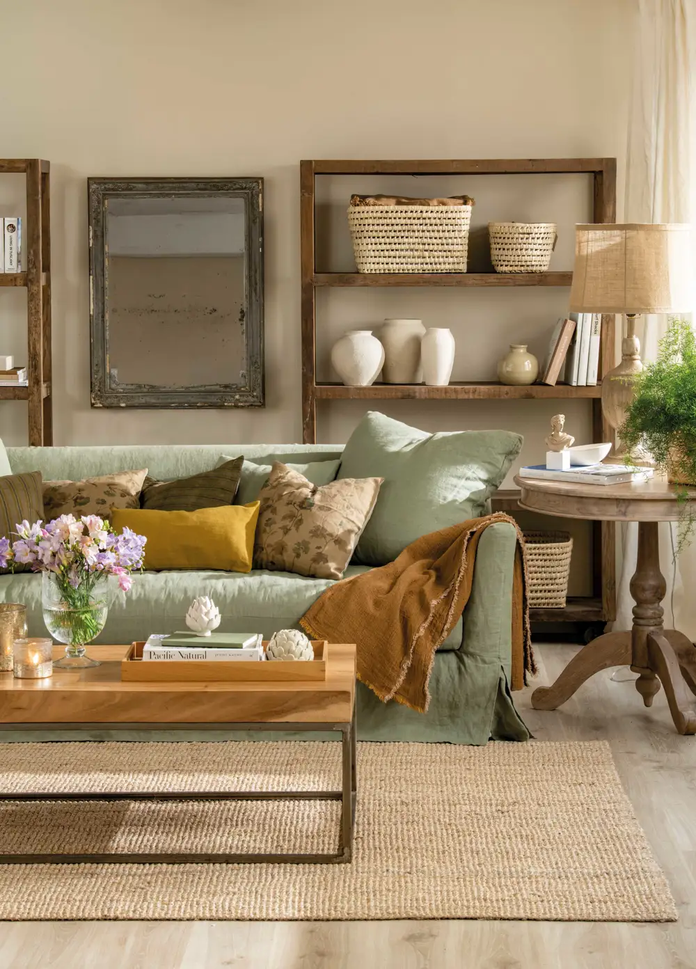 Salón con sofá verde, estanterías de madera y jarrones de cerámica