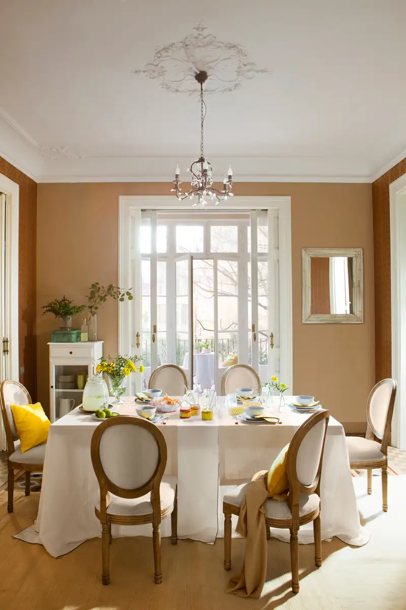 Comedor con rosetón y molduras y lámpara de araña.