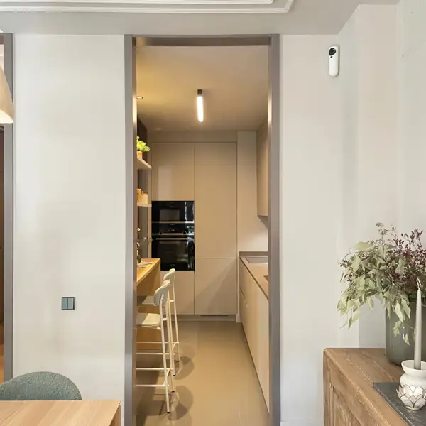 Una cocina PEQUEÑA y ESTRECHA (de 7m2) con ideas para aprovechar el espacio: tiene barra para desayunar y un estilo moderno y acogedor