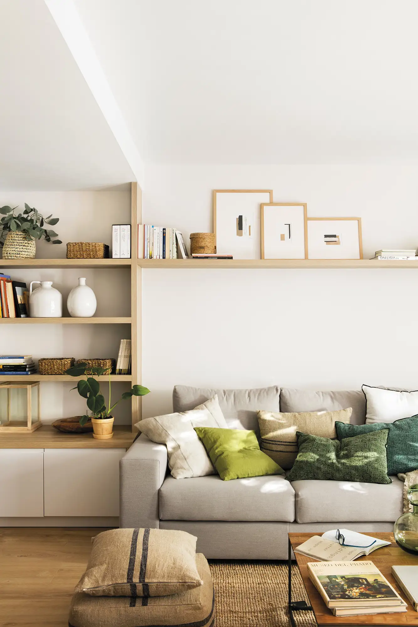 Salón en tonos neutros con cojines de color verde.