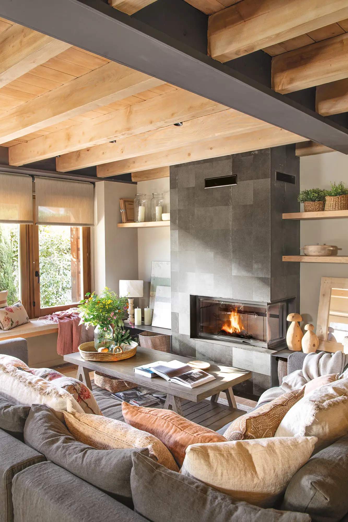 Salón pequeño de montaña con chimenea y sofá gris en L 