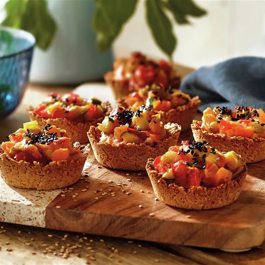 Cestitas de avena gratinadas con verduras variadas y semillas de sésamo negro