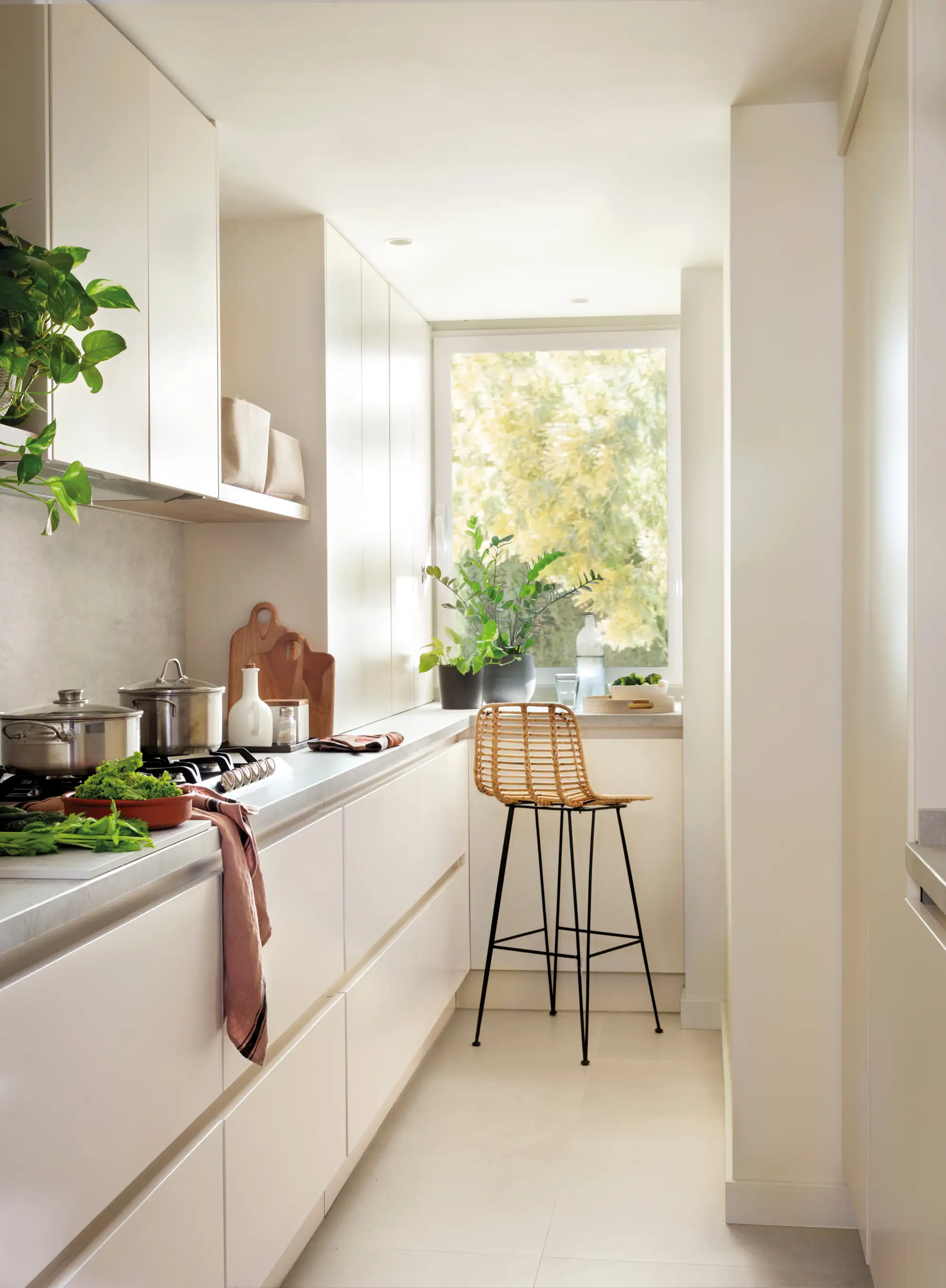 Cocina pequeña con frentes lisos y barra de desayunos bajo la ventana.