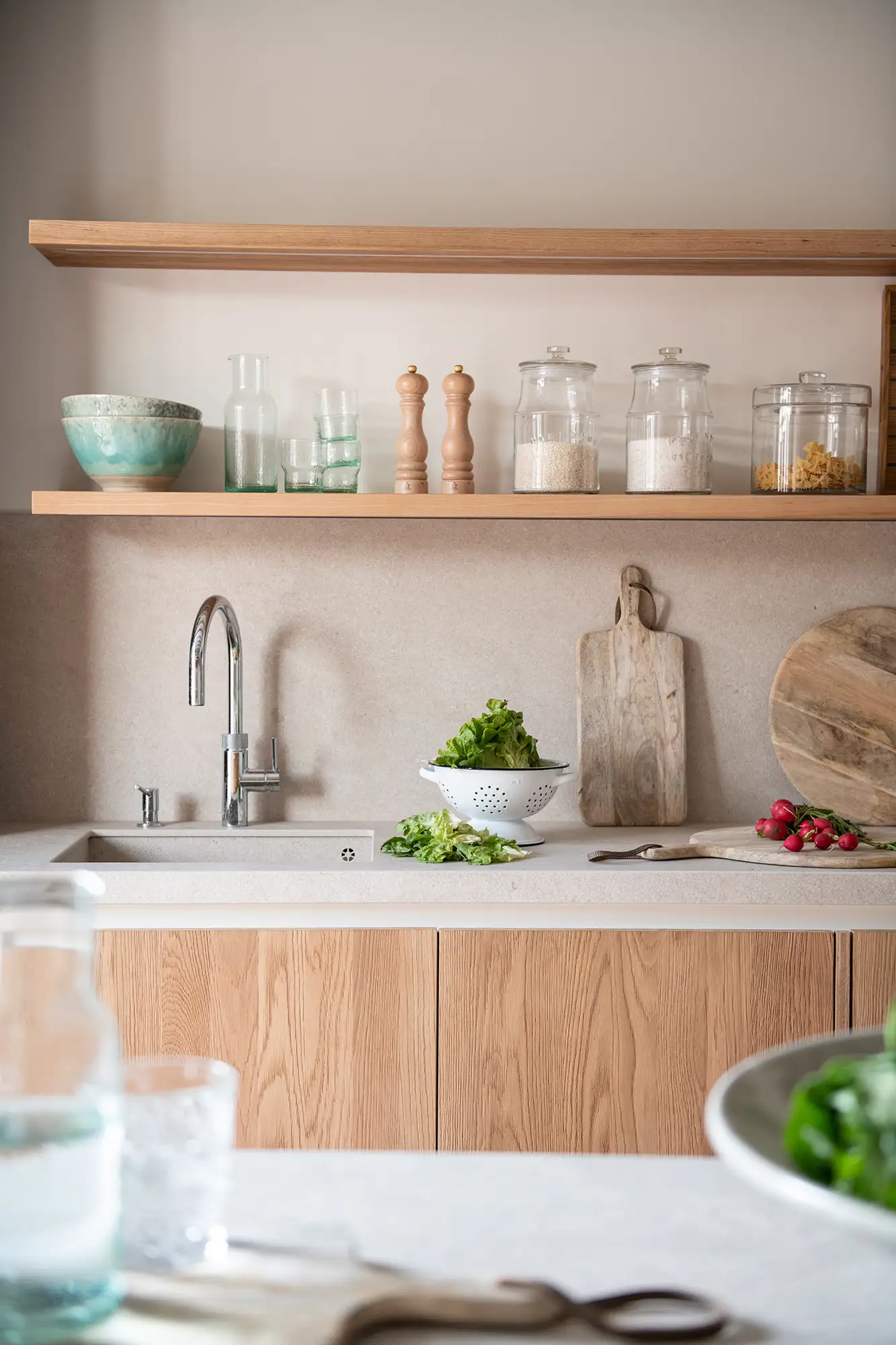 Armarios de cocina en madera y estantes flotantes.