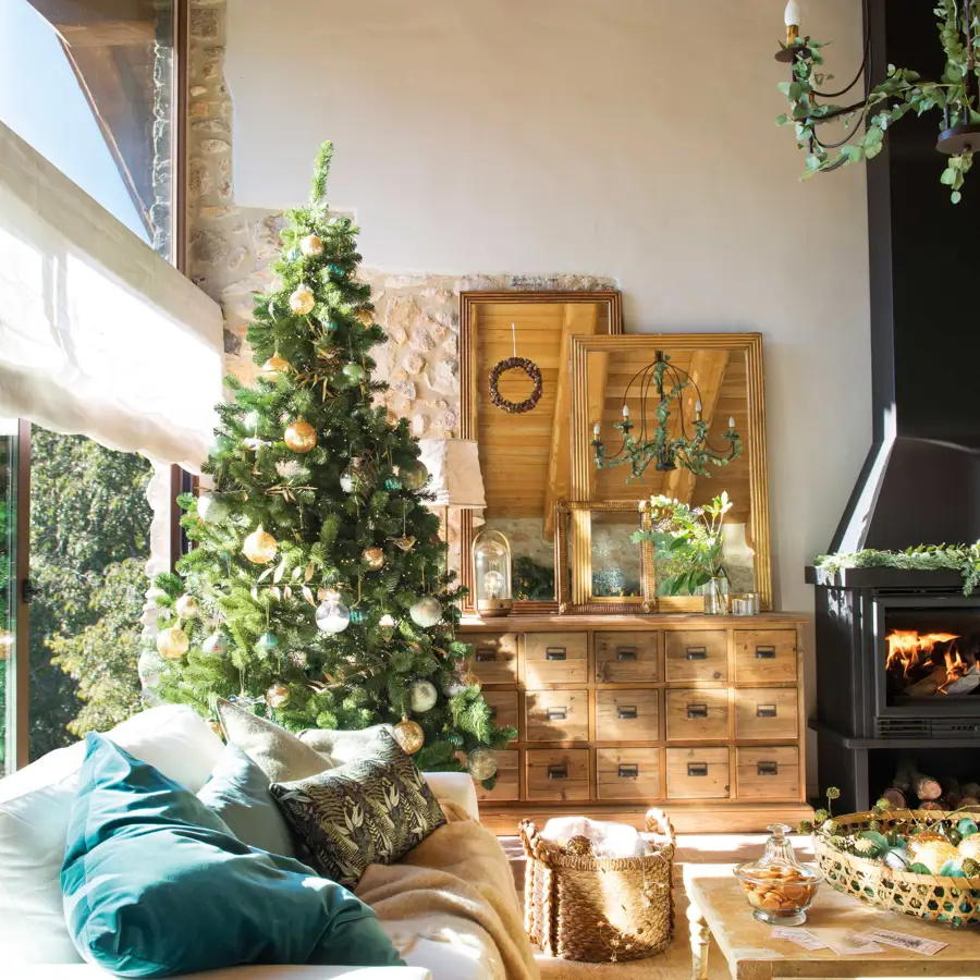 Detalle de salón con cómoda de madera y árbol de Navidad