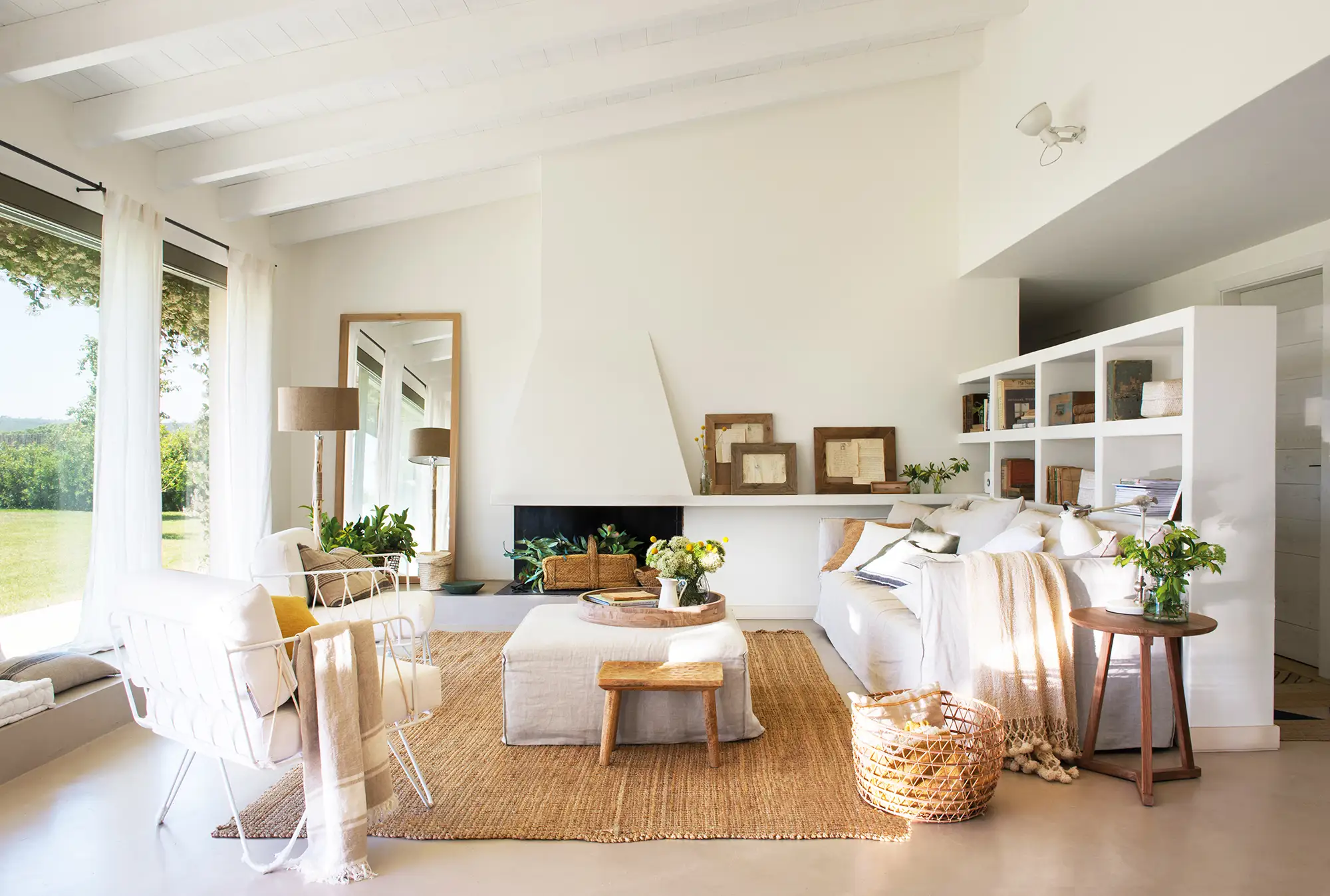 Salón blanco con librería en la trasera