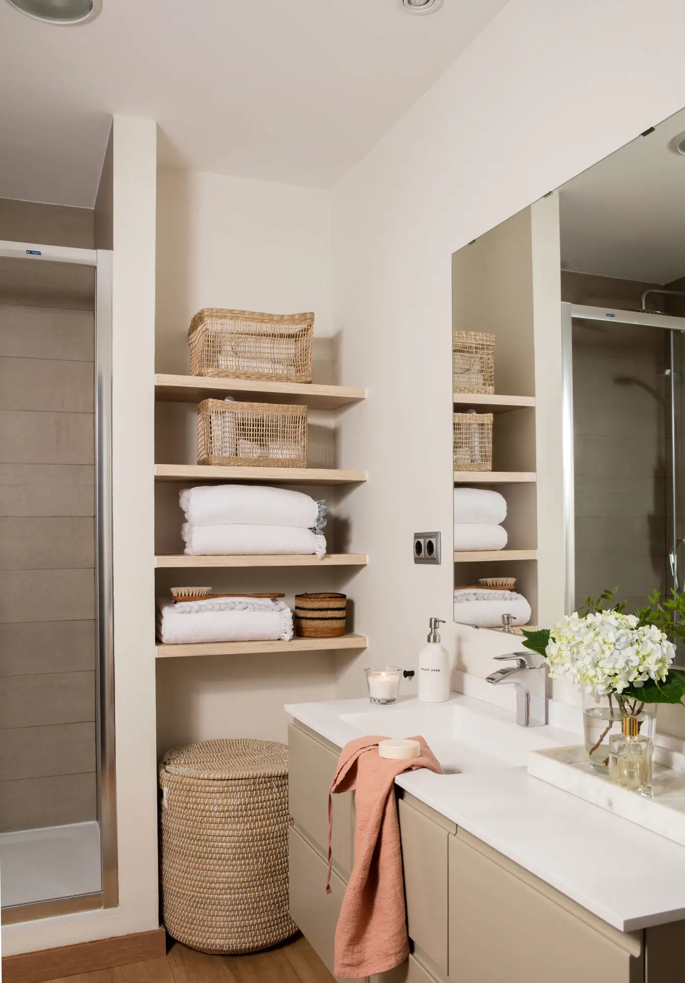 Baño con estantes de madera en un entrante de la pared.