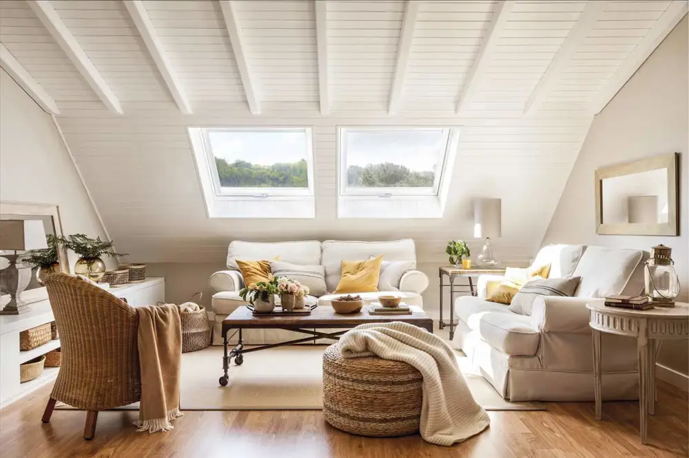 Salón abuhardillado con techo madera blanca