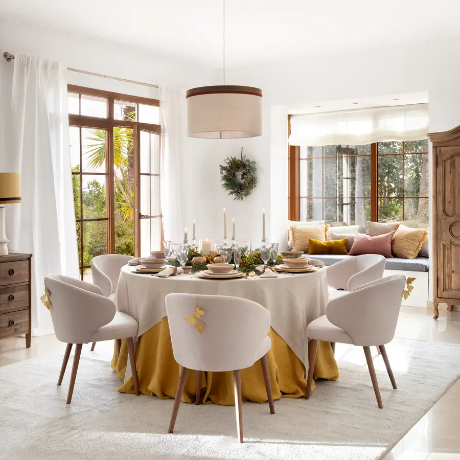 Comedor con mesa redonda y sillas tapizadas decorado de Navidad