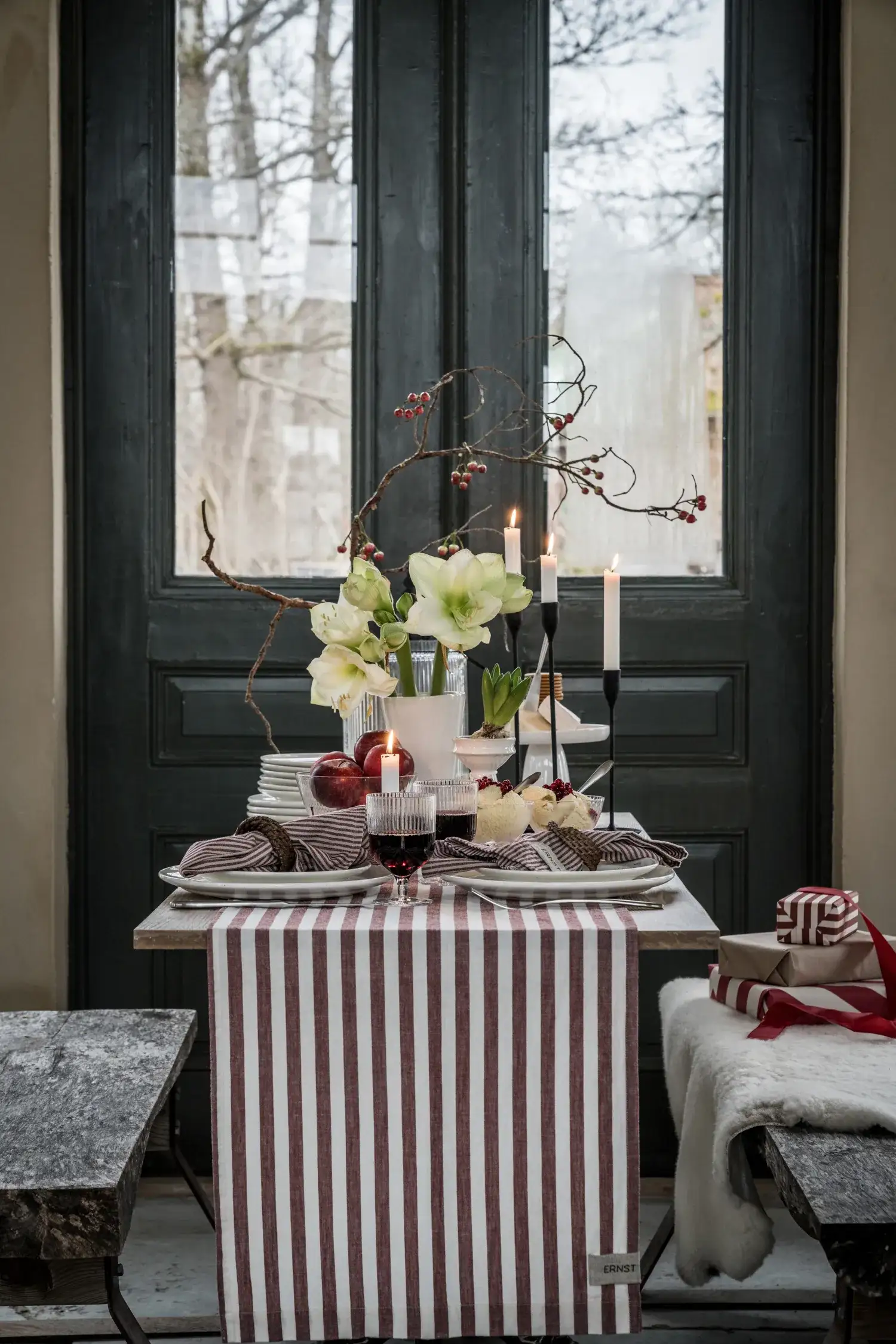 Mesa de Navidad decorada con un mantel a rayas y copas de cristal