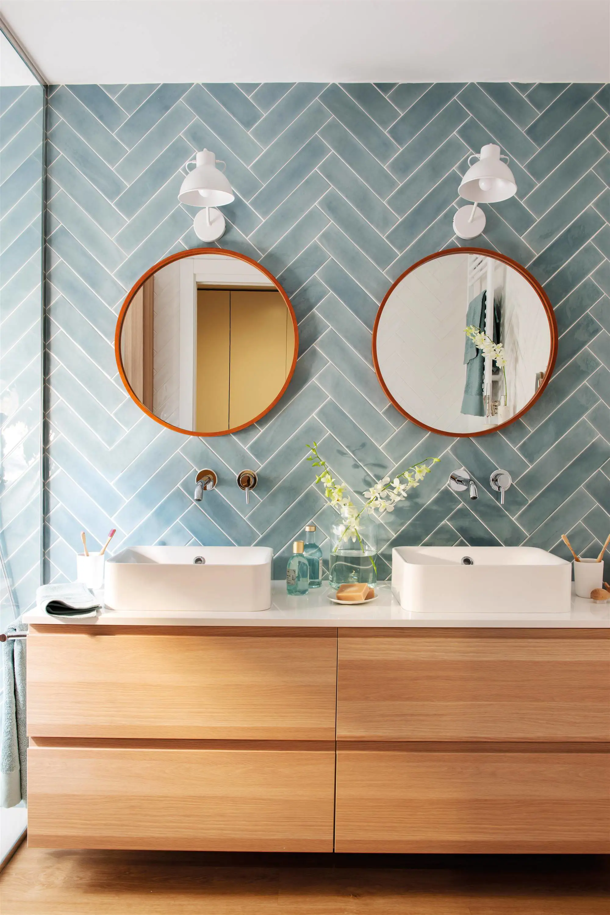 Baño con azulejos azules y mueble de madera