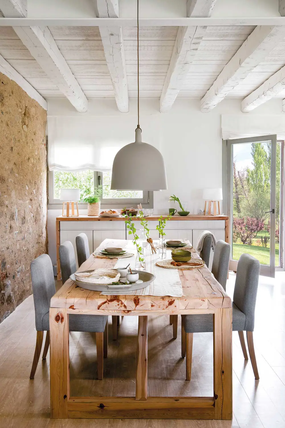 Comedor con mesa de madera y sillas tapizadas en gris