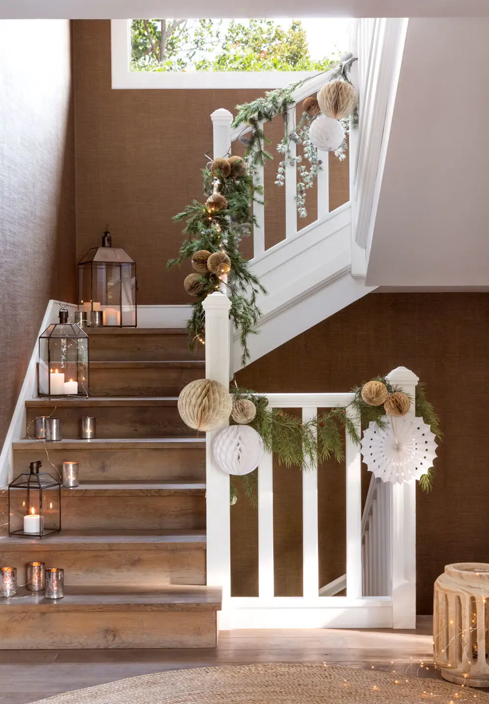 Escalera decorada con adornos navideños en colores neutros