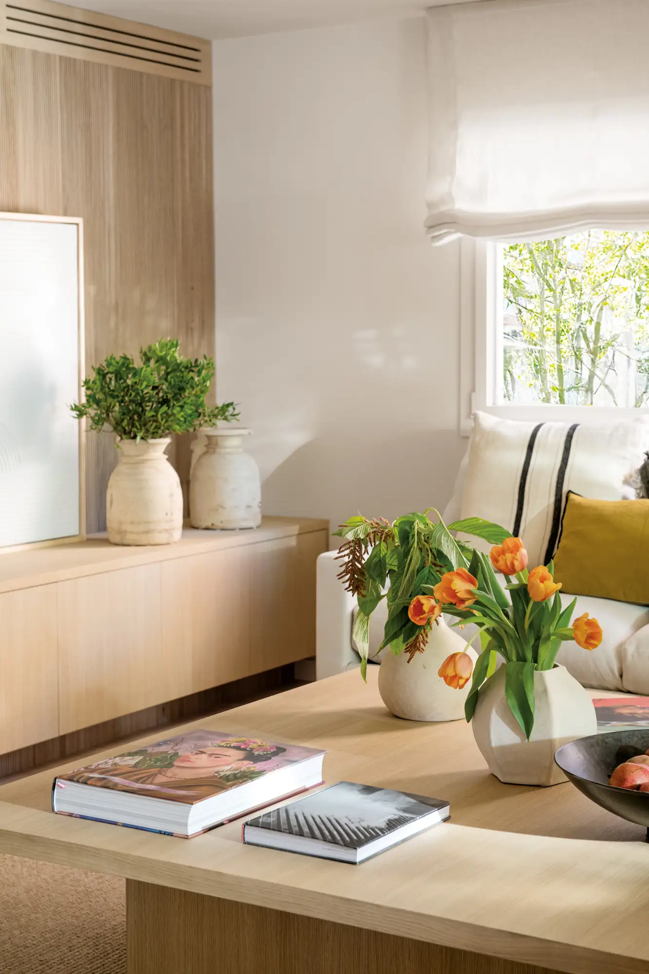 Mesa de centro de madera con jarrones y libros decorativos