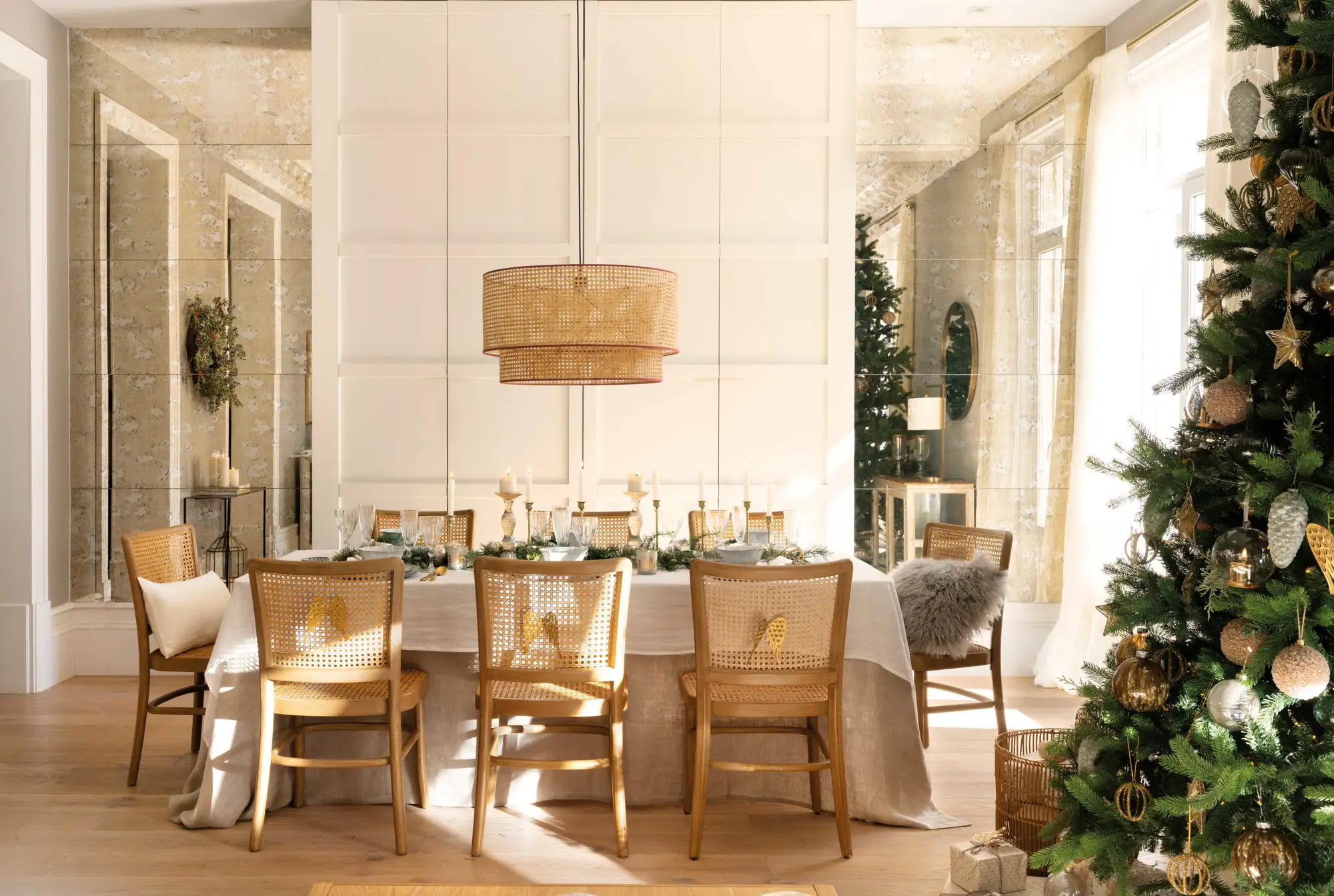 Comedor de Navidad con mesa vestida, lámpara suspendida y sillas decoradas