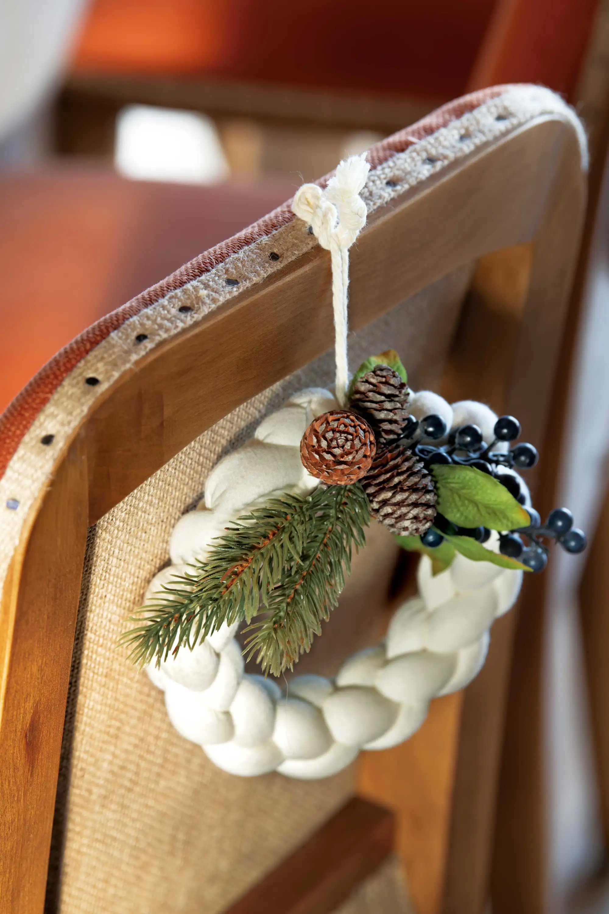Detalle de silla decorada con corona blanca trenzada de fieltro