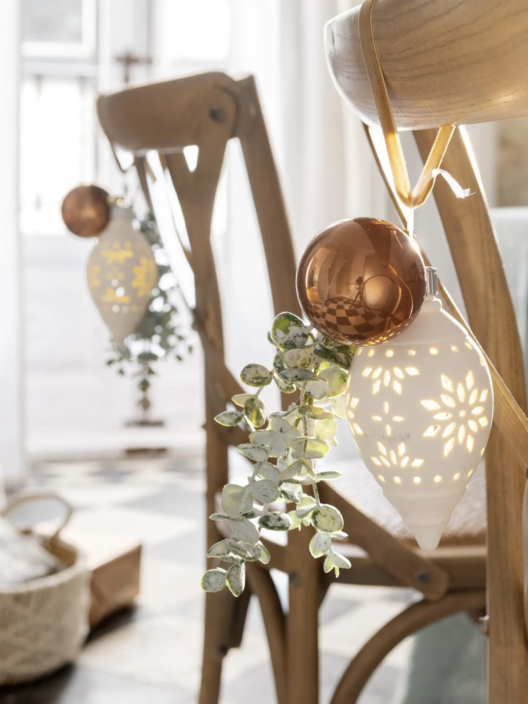 Silla decorada con bolas de navidad y rama de eucalipto