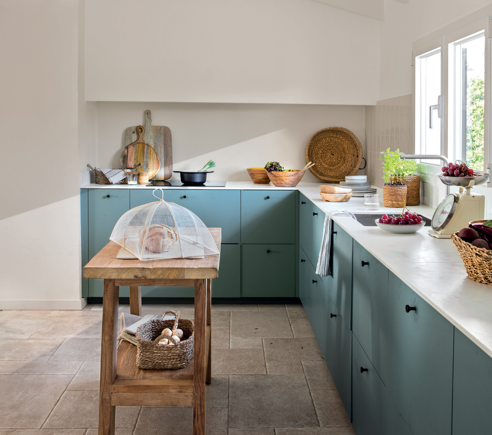 Cocina con distribución en L y muebles en azul verdos