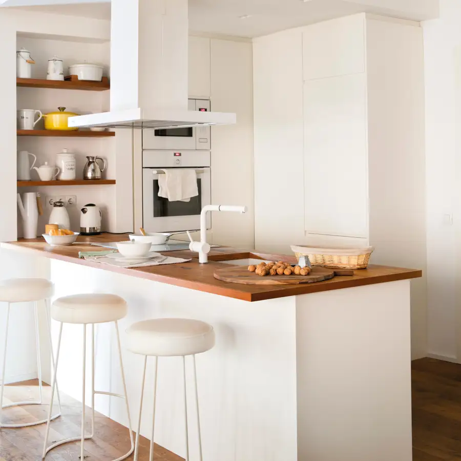 Cocina pequeña y moderna con grifo blanco, península y taburetes