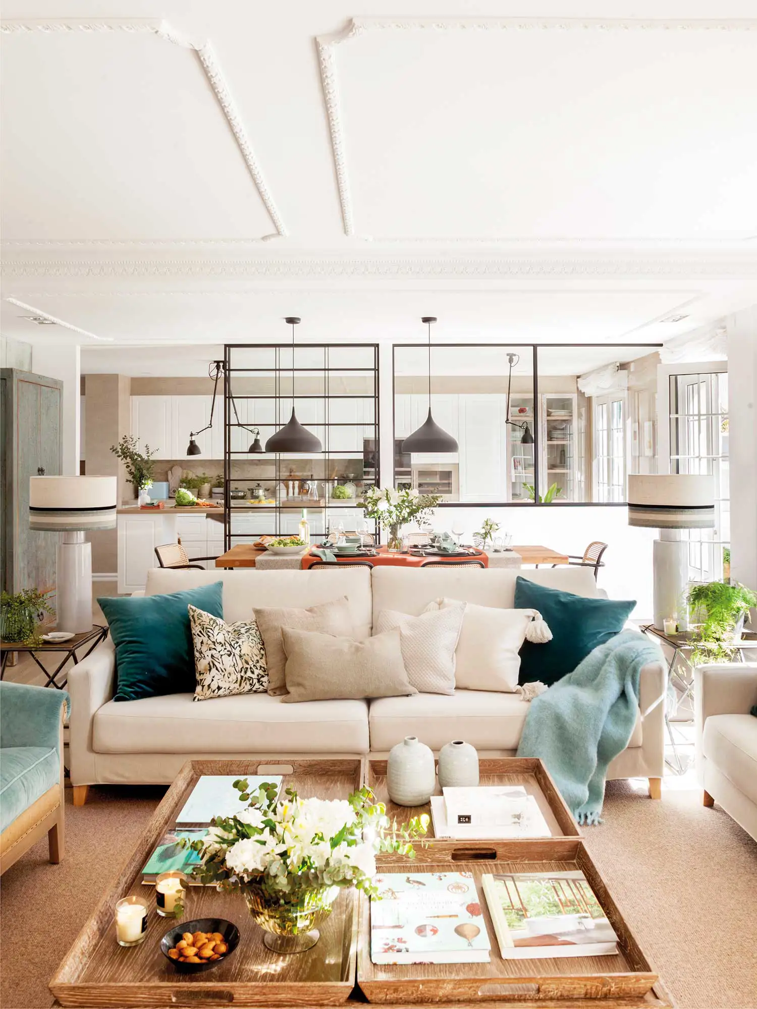 Salón, conectado con el comedor y la cocina, con cojines de terciopelo verde