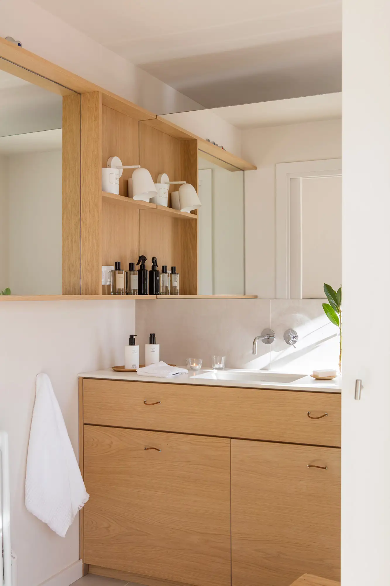 Baño con estantes de pared de madera.