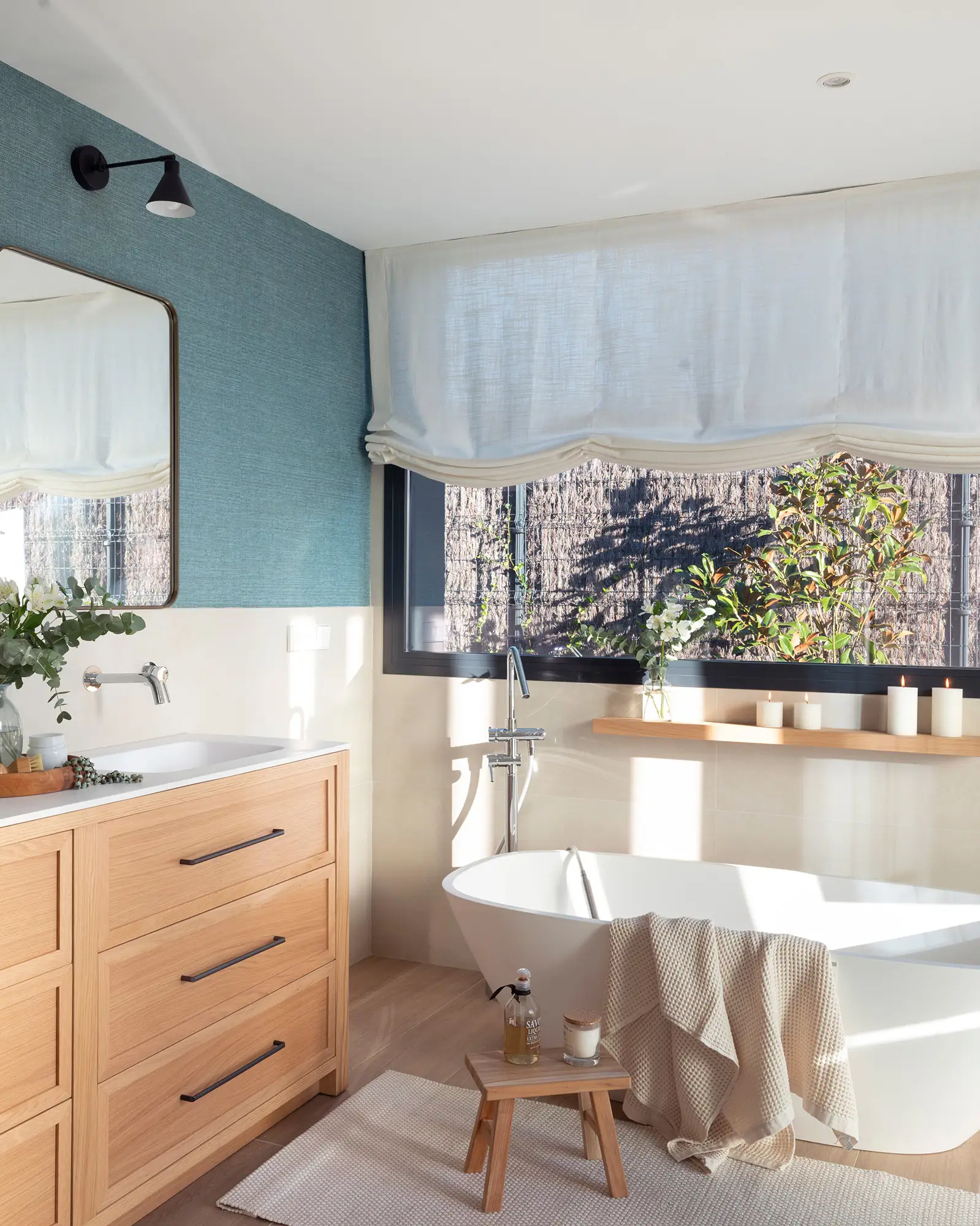 Baño moderno con bañera exenta y mueble de madera.