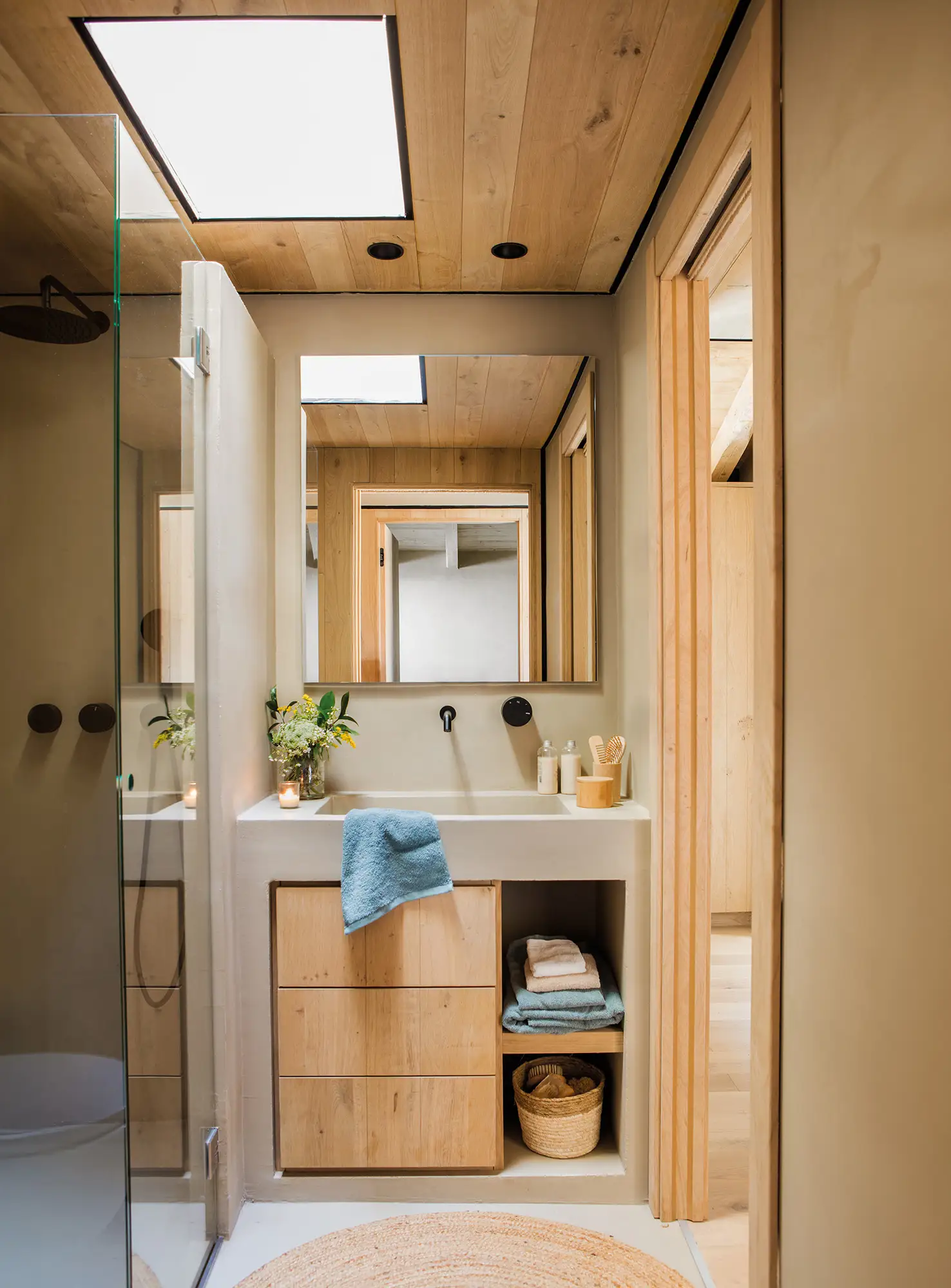 Baño pequeño y moderno con mueble de obra y cajonera de madera.