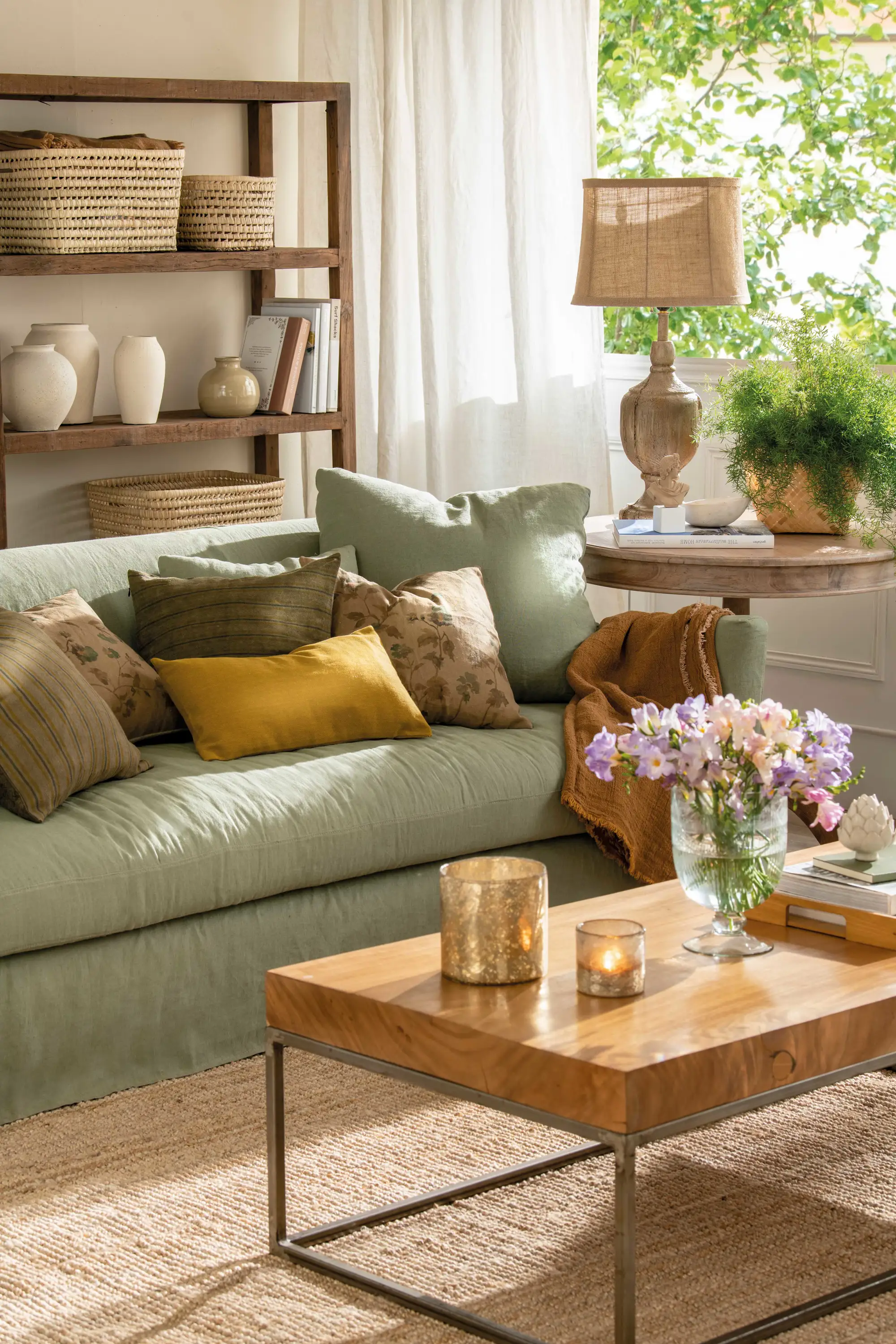 Salón con sofá verde y mesa auxiliar con lámpara de sobremesa