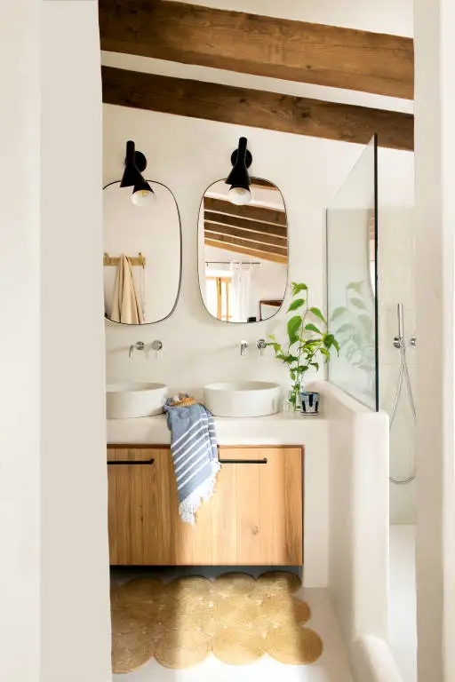 Baño con mueble de microcemento y puertas de madera. 