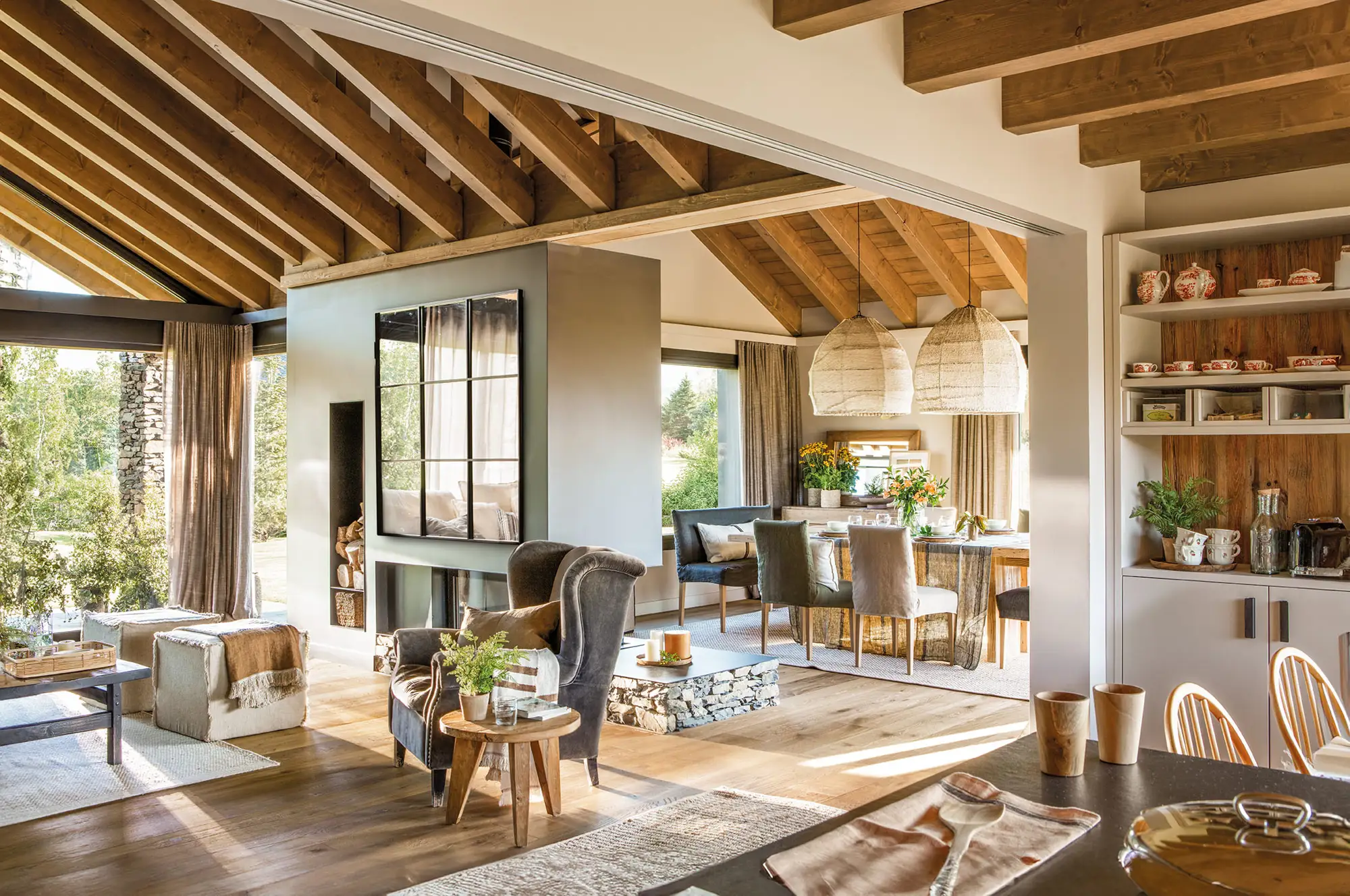 Salón comedor rústico con chimenea y vigas de madera