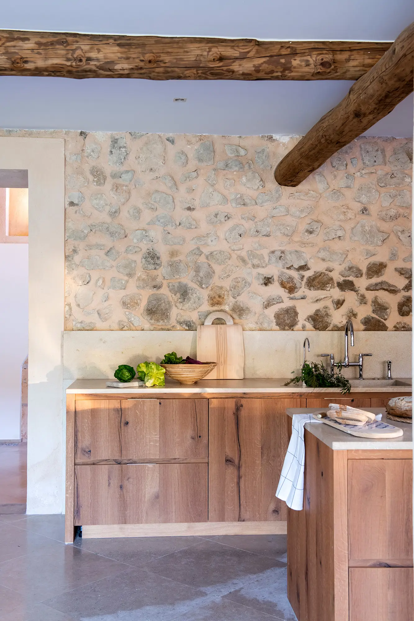 Cocina con pared de piedra y zócalo 