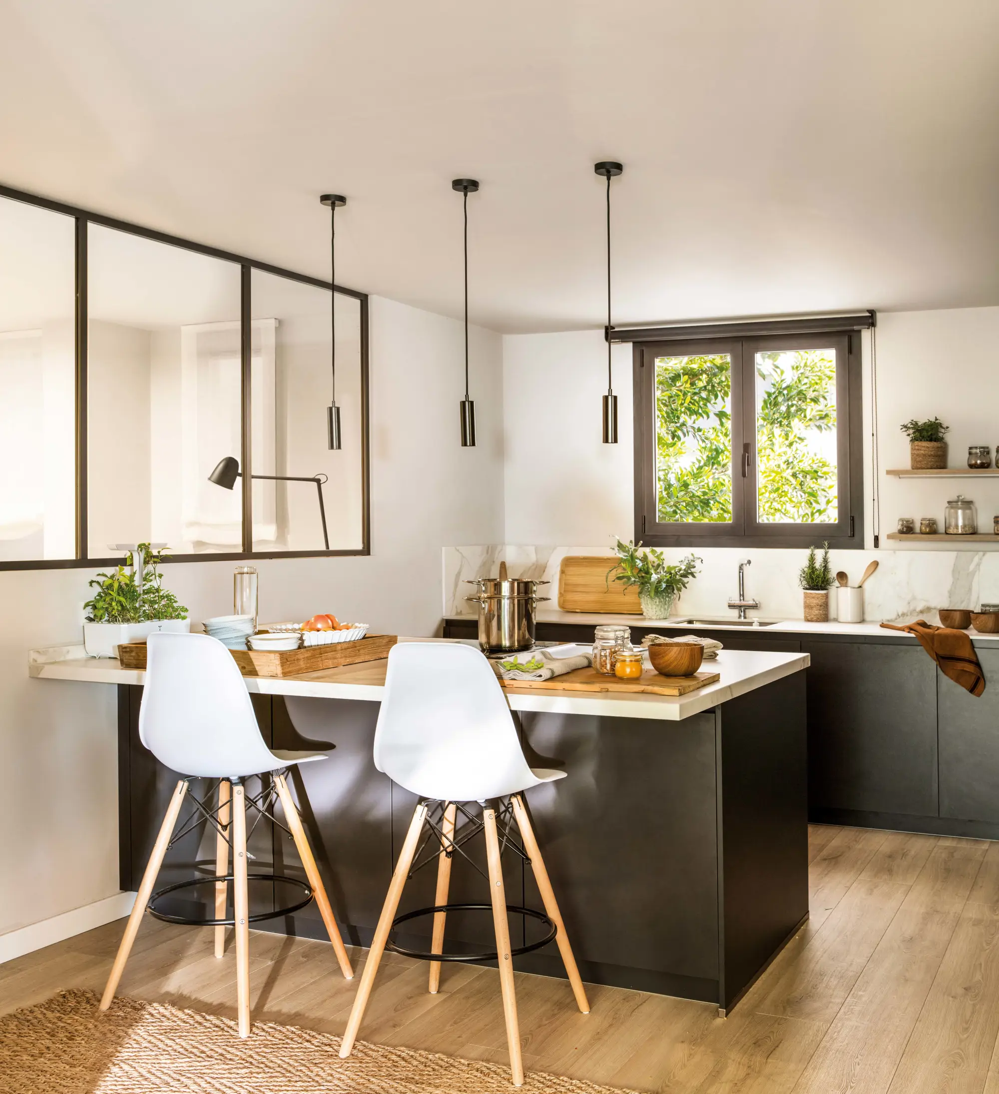 Cocina en blanco y negro con tabique de cristal a modo de ventanas