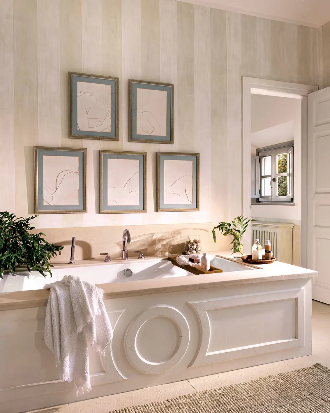 Un baño con cuadros y una bañera señorial