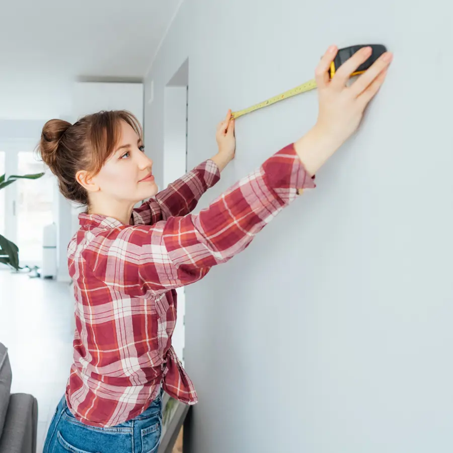 Mujer midiendo en la pared