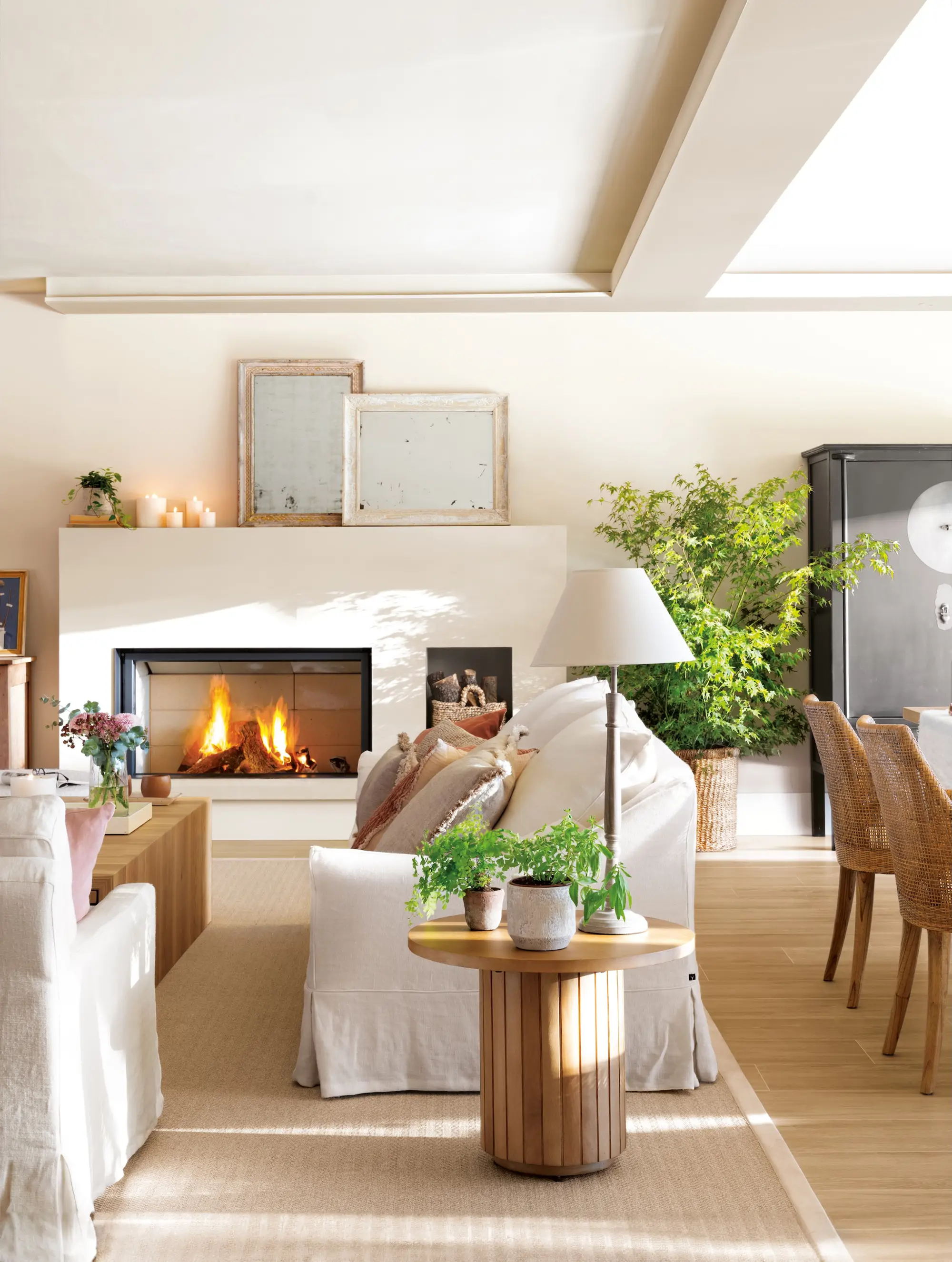 Salón comedor con chimenea, sofás de lino y mesa auxiliar redonda