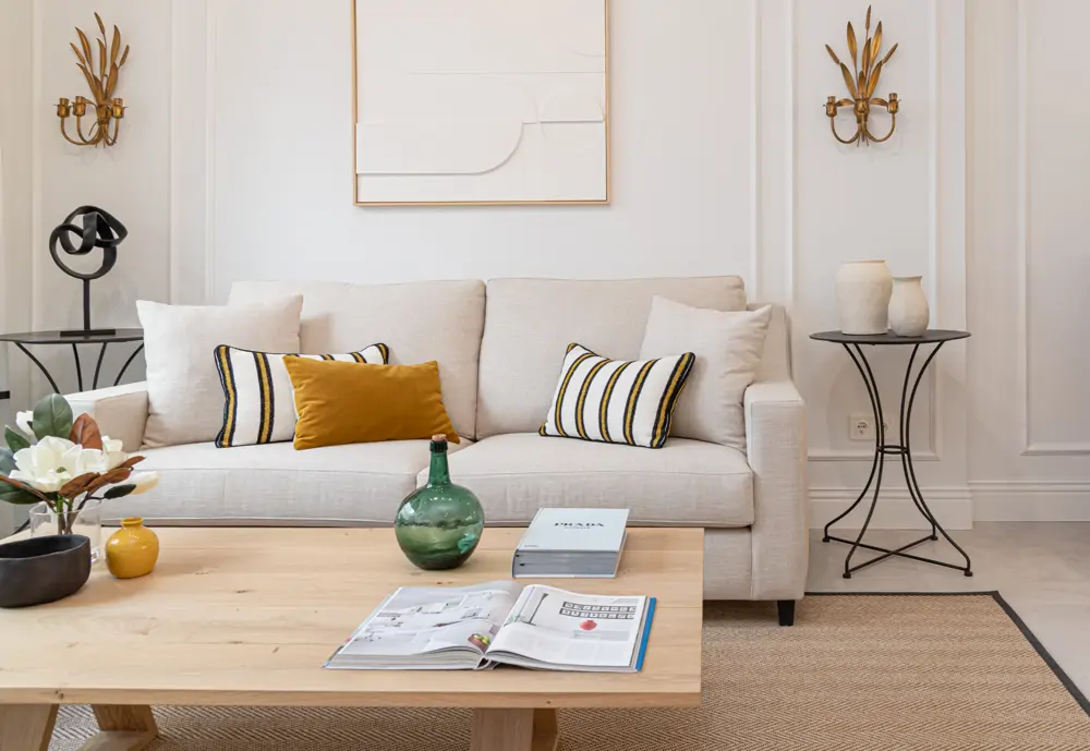 Sofá con panel decorativo en la pared y cojines estampados
