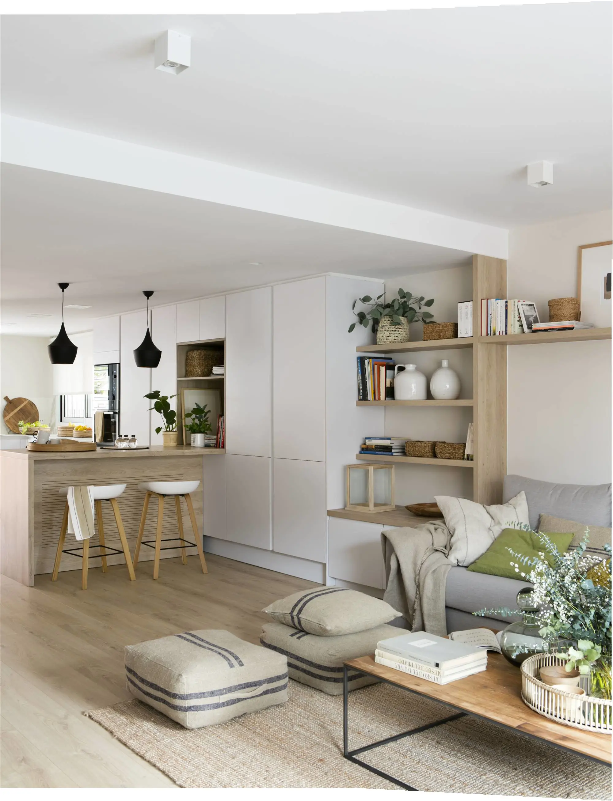 Cocina abierta al salón con mueble panelado y estantería abierta