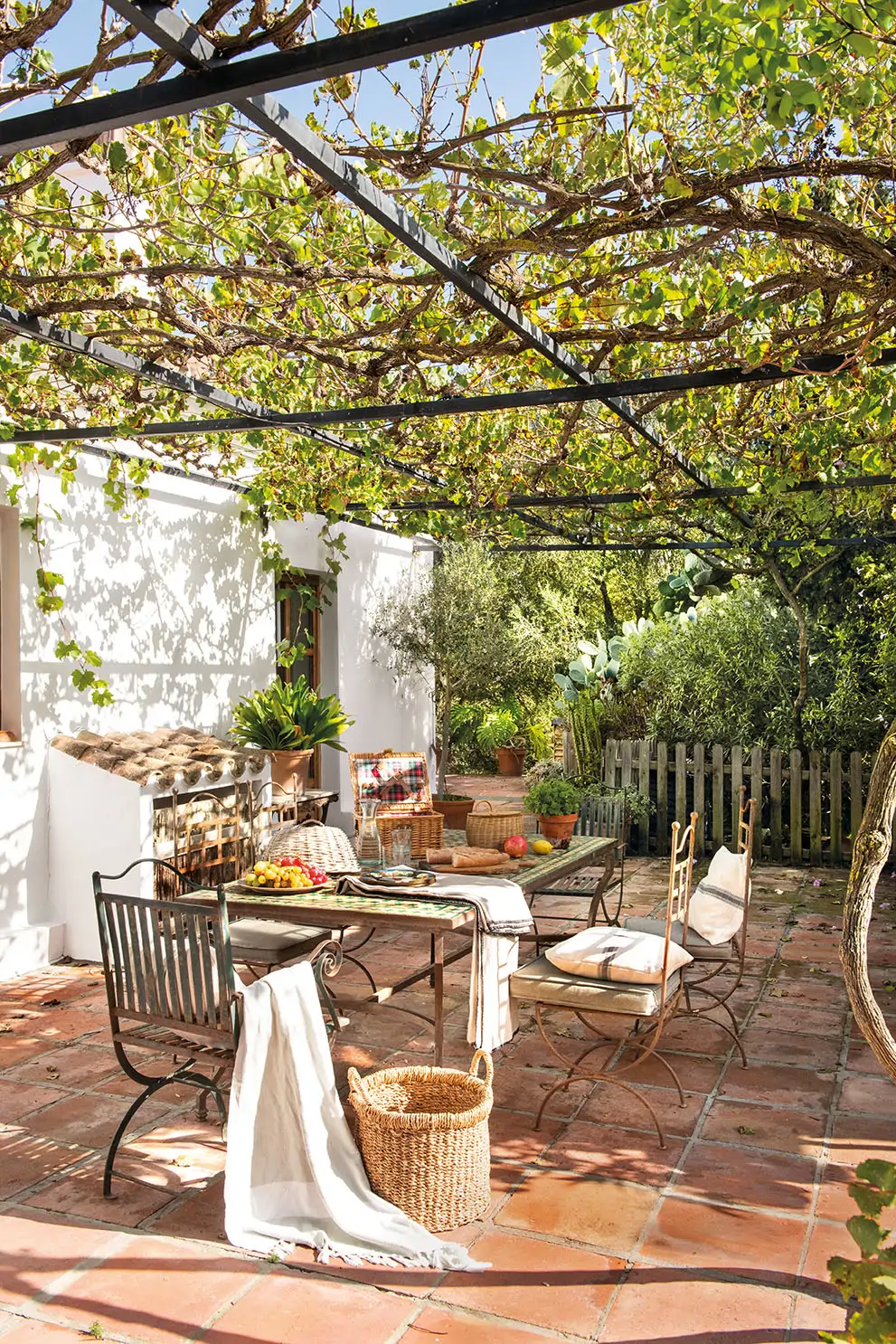 Un comedor exterior con mobiliario de forja