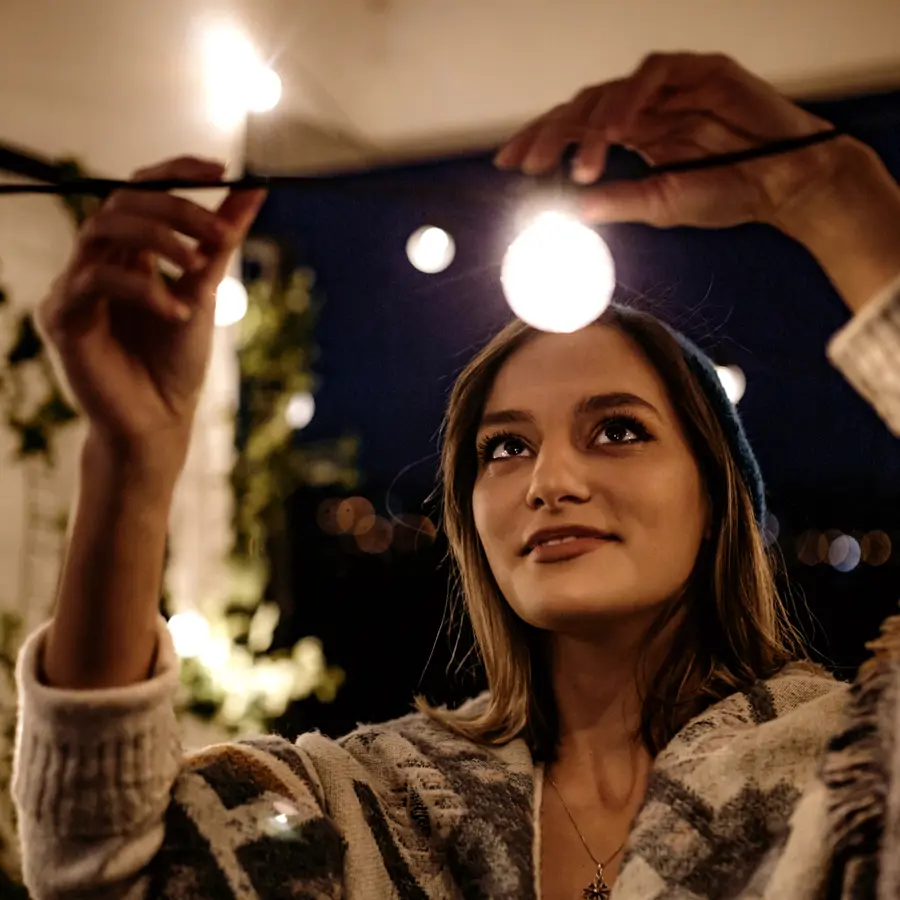 Mujer colocando luces en su terraza
