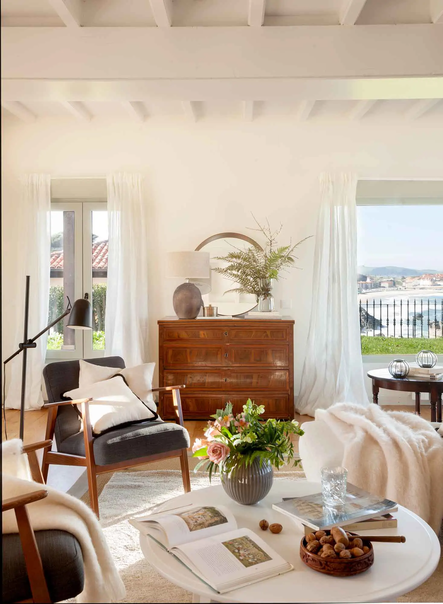 Salón con butaca y mueble antiguo detrás.