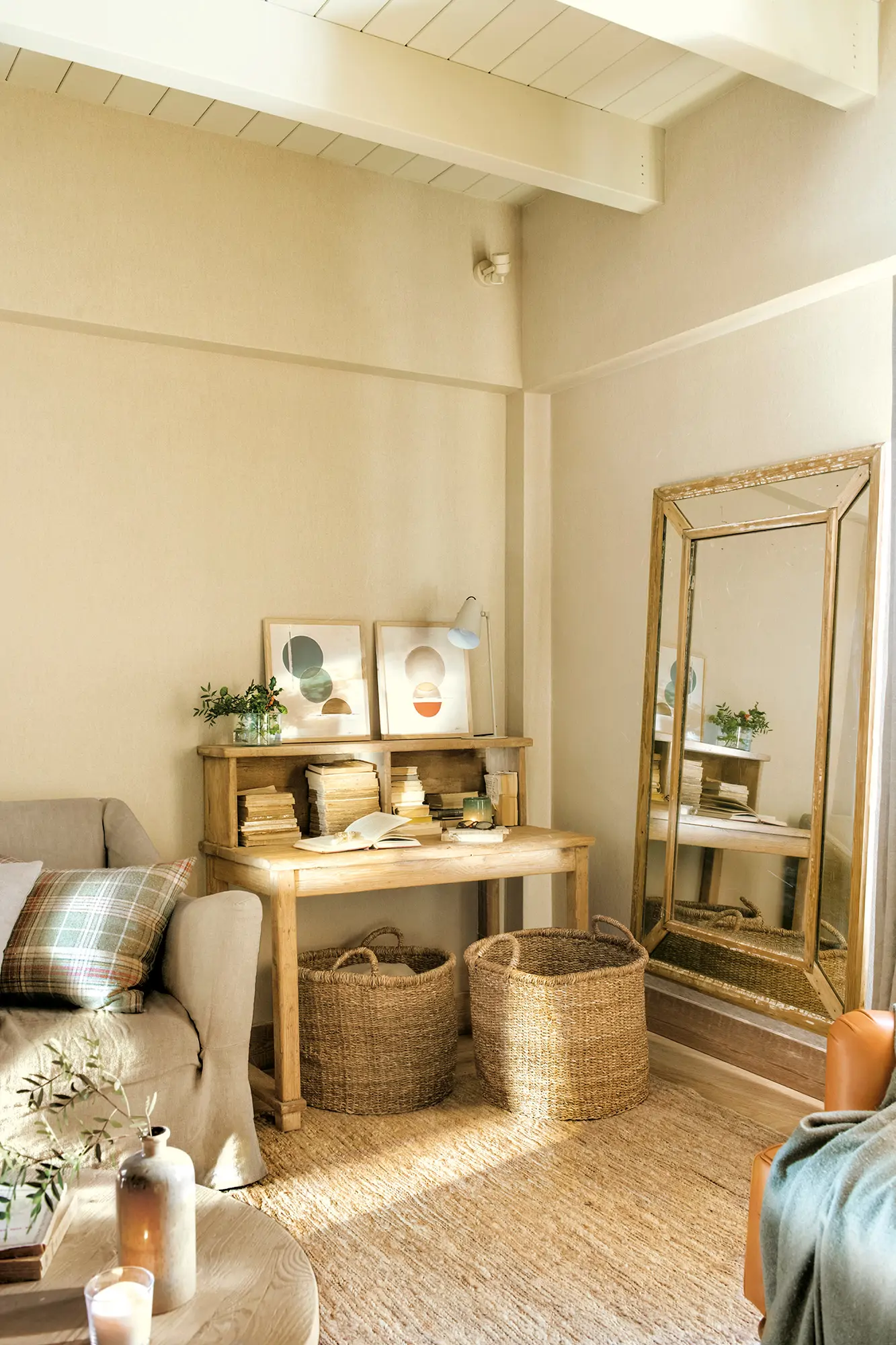 Rincón del salón con escritorio de madera y gran espejo de pie